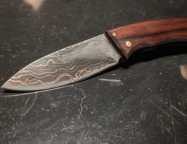 Couteau pliant à cran plat en damas cuivre.
